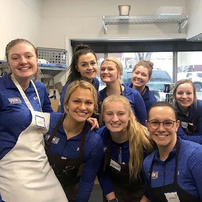 Group of smiling students volunteering at soup kitchen