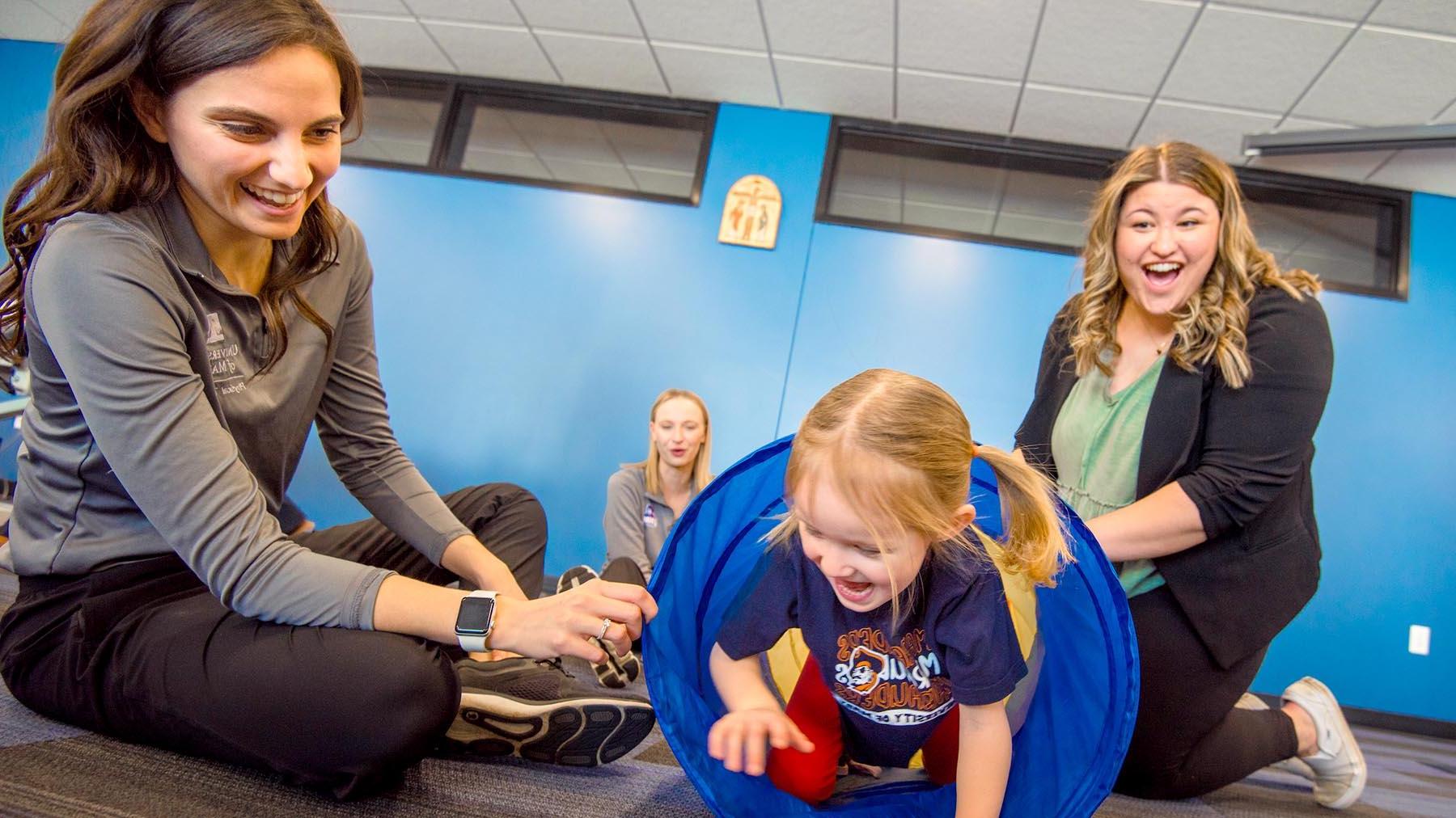 Physical Therapy students with child